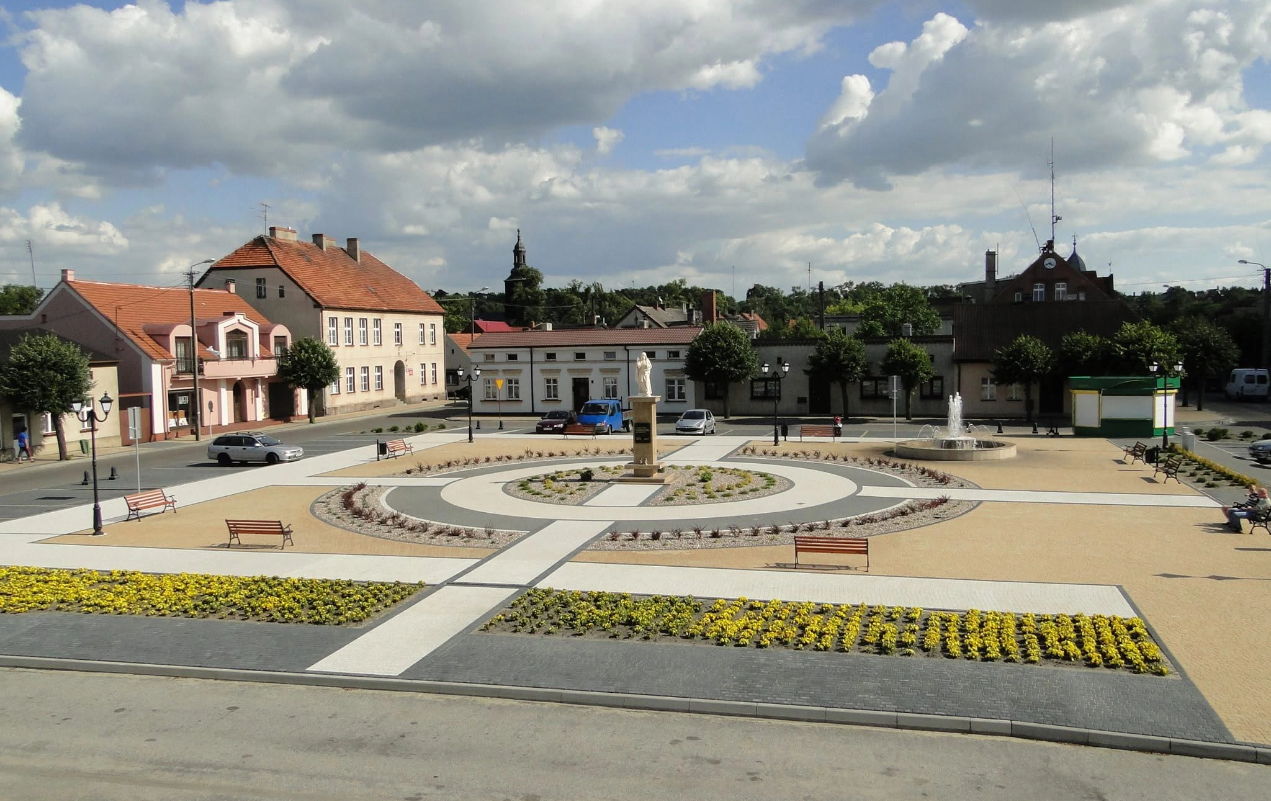 Zdjęcie rynku miasta z&nbsp;pomnikiem w&nbsp;centralnym punkcie